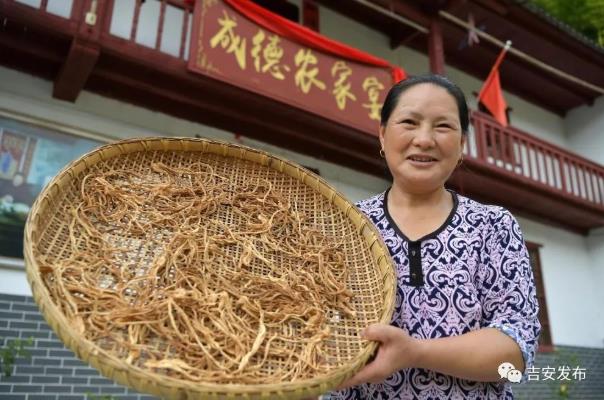 神山村村民彭夏英在自己開(kāi)的農(nóng)家樂(lè)前展示自家的農(nóng)產(chǎn)品