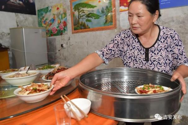 神山村村民彭夏英在自己開(kāi)的農(nóng)家樂(lè)給游客上菜